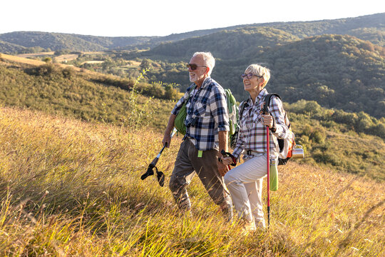 Active old woman and man walking at field and enjoy