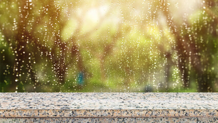 Stone marble table top on window glass with raindrops after summer rain. Can be used for display or...