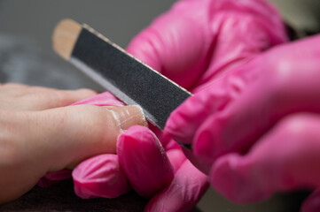 Obraz premium The master makes hardware pedicures to the client. 