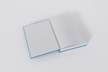 Mockup of a rectangular open on the first-page book with a blank, blue glossy cover on white background. Isolated with clipping path.