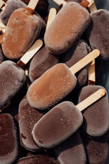chocolate ice cream on a stick, a lot of cold ice cream with frosting on the glaze, pattern, background