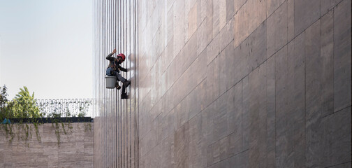 Window cleaner is working on the office building facade