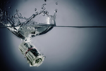 US Dollar bills sinking in water as symbol of global economic and financial crisis and recession. Copy space.