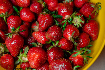 delicious strawberries in a yellow bowl on the table