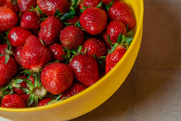 delicious strawberries in a yellow bowl on the table