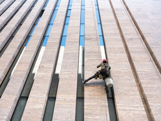 Window cleaner is working on the office building facade