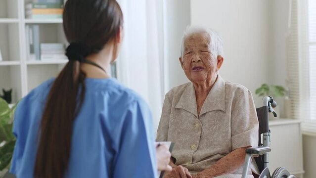 Young Asian woman, nurse, caregiver, carer talk with a senior Asian woman at home to follow up result by checklist.