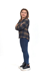 side view of a full portrait of a women with jeans and sneaker arms crossed and looking at camera on white background