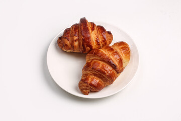 Fresh baked croissant served in white plate