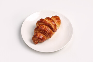 Fresh baked croissant served in white plate