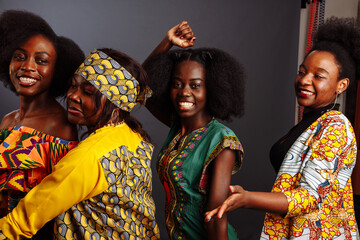 Four young beautiful African fashion models have fun and laughing in traditional dress. Women from the Congo Republic, Ivory Coast, and Zimbabwe - obrazy, fototapety, plakaty