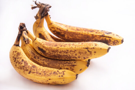 Very ripe bananas, almost spoiling pictured on white background, selective focus.