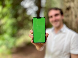 blurry focus only phone in focus very handsome man french italy not holding a phone with a green...