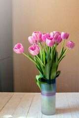 Bouquet of pink tulips in a vase on a white background. Holiday gift.