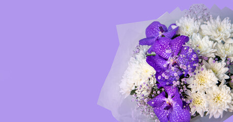 Lovely bouquet with lilac orchids and white chrysanthemums, isolate on purple background with copy space. Floral card.