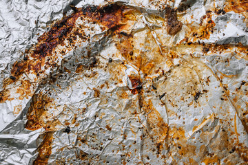 Background, texture, top view of dirty, greased, sunflower oil after cooking a meat dish, foil. Food photography.