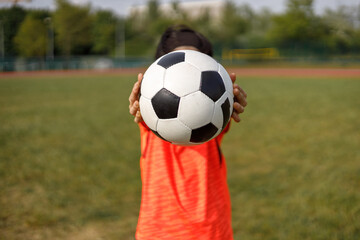 Girl holding with hands a soccer ball
