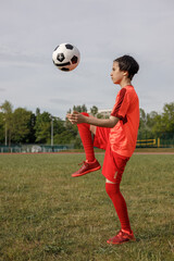 Girl kicking the soccer ball with her knee 