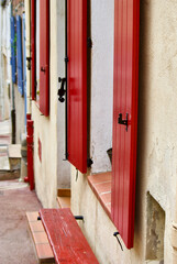 Townhouse with red shutters in a row in a small village in Provence in France.