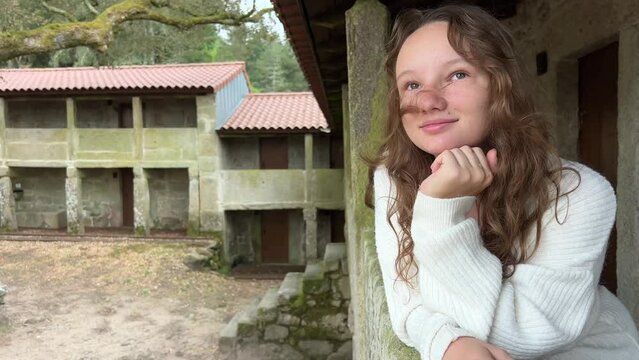 monastery of Sao Joao d Arga mosteiro e igreja de Sao Joao dArga teen girl looks around she is in a white sweater and blond hair without makeup. High quality 4k footage