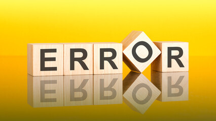 error - text of on wooden cubes, reflected from the bright yellow surface
