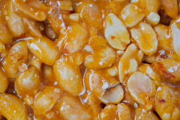 Top view: caramelized nuts fried in honey - Gozinaki - orange granola peanut bar - close up, macro. Traditional Georgian cuisine, oriental sweet, gastronomy and food concept