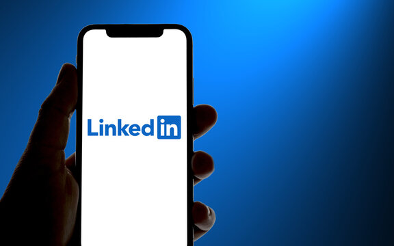 LinkedIn logo is displayed on a modern smartphone, in the background a color gradient showing the colors of the LinkedIn logo, social networks, career, 2022