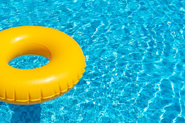 Yellow ring floating in refreshing blue swimming pool