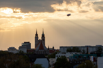 Zeppelin fliegt an der Johanniskirche in Magdeburg, Sachsen-Anhalt, Deutschland, im Sommer vorbei