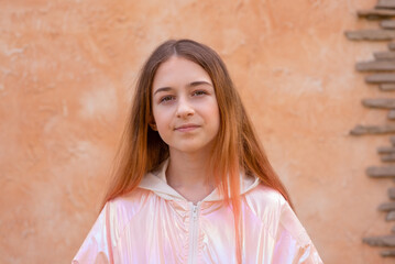 Girl 11 years old on a background of beige wall. Teen girl portrait.