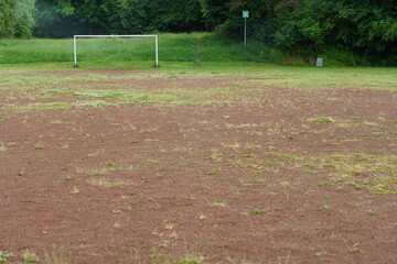 Pause auf einem leeren Sportplatz mit Bänken und rotem Sand