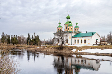 Fototapeta na wymiar OLONETS, RUSSIA - May 09, 2022: View of the Smolensk Cathedral of the icon of the mother of God from the side of the river Megrega in twilight