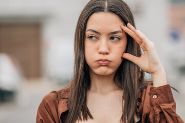 girl with expression of anger or fury outdoors - obrazy, fototapety, plakaty