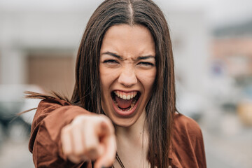 girl pointing screaming angry outdoors