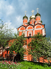 red orthodox church with a beautiful white pattern and a black dome