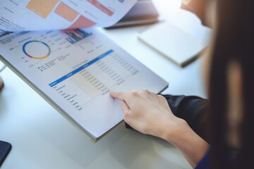 Teamwork concept, consultation, female economist pointing to budget, finance and investment documents, discussing and planning finances with male advisors in conference room