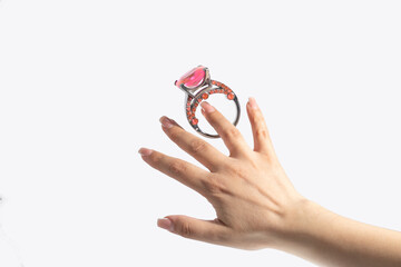 Woman's hand puts on a large engagement ring with a pink diamond.