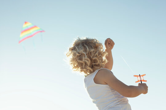 Anonymous child launching colorful kite