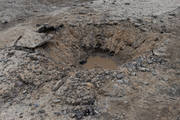 Hole in the ground at Gostomel airport caused by Russian artillery