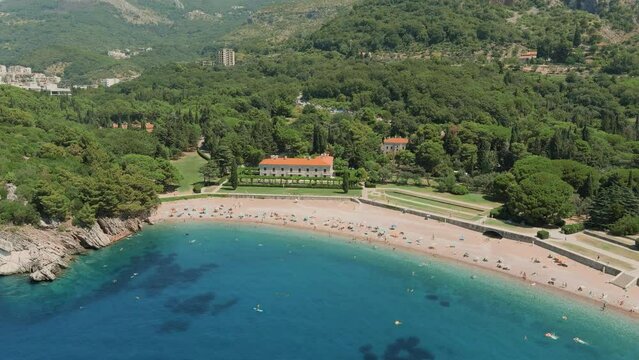 Montenegro. Adriatic Sea. Milocer beach. Summer. Sunny weather. High season. A very popular tourist spot. Drone. Flight. The camera moves from left to right