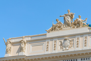 Lviv, Ukraine - May 2022: The upper part of Ivan Franko National University main building with National Flag of Ukraine. Allegorical sculpture composition Galicia, Vistula and Dniester. 