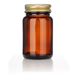 Blank glass jar for tablets or pills on white background of insulation. Metal gold nut, cap.