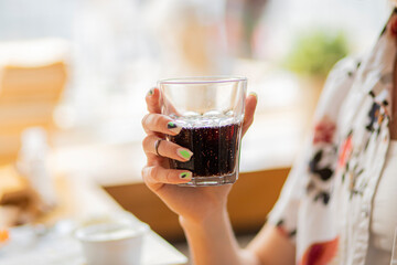 person holding a glass of red wine drink or cola