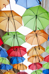 Umbrellas exhibition, street decorated. the sky is filled with colorful umbrellas. Many colorful umbrellas against the sky in city settings.