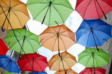 Umbrellas exhibition, street decorated. the sky is filled with colorful umbrellas. Many colorful...