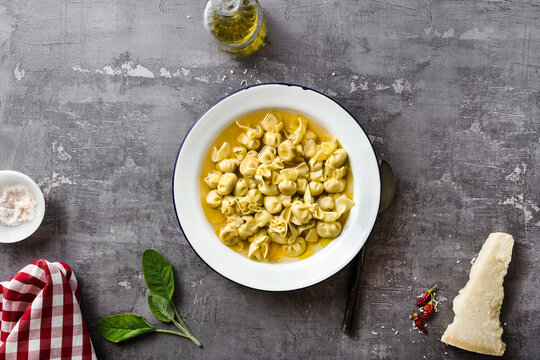cappelletti in brodo. Italian dish for family holidays. on the table with parmesan