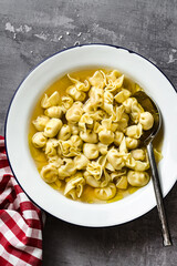 cappelletti in brodo. Italian dish for family holidays. on the table with parmesan