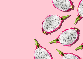 Pitahaya. Flat lay photo. Halves of dragon fruits on pink background