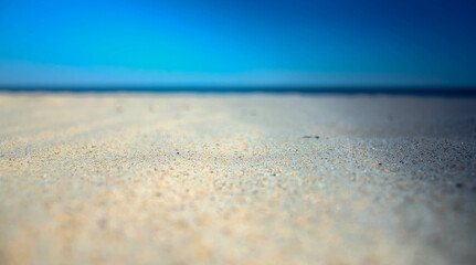 Fototapeta na wymiar smooth sea sand on the coast and blue sky