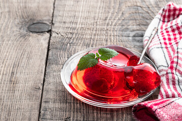 Fruit jelly with fresh strawberry on rustic wooden table